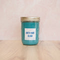 Blue candle in a jar labeled 'South Padre Island' on a white surface.